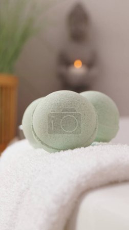 Photo for Towel with bath bombs on tub indoors, closeup - Royalty Free Image