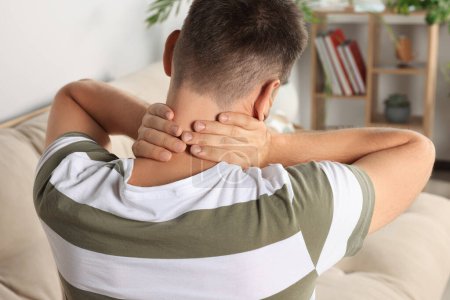 Téléchargez les photos : Man suffering from neck pain indoors, back view - en image libre de droit