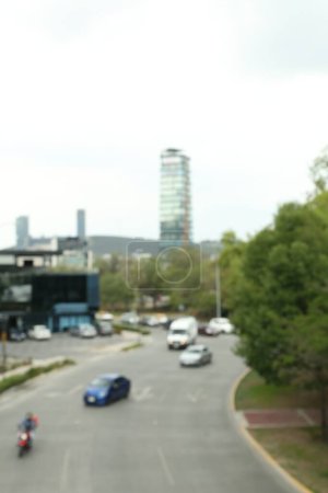 Téléchargez les photos : Voitures modernes sur la route près des arbres et du bâtiment, vue floue - en image libre de droit