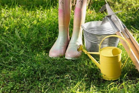 Téléchargez les photos : Arrosoir, outils de jardinage et bottes en caoutchouc sur herbe verte à l'extérieur - en image libre de droit