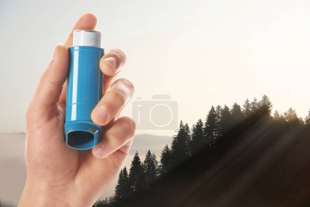 Photo for Man with asthma inhaler in mountains, closeup. Emergency first aid during outdoor recreation - Royalty Free Image