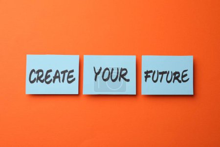 Téléchargez les photos : Expression motivationnelle Créer votre avenir faite de notes collantes avec des mots sur fond orange - en image libre de droit