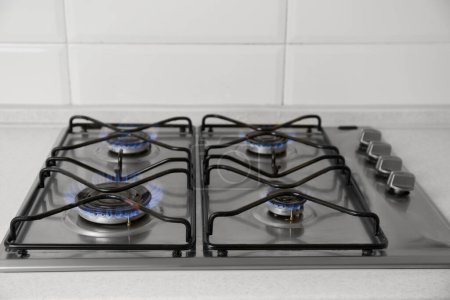 Téléchargez les photos : Table de cuisson au gaz avec flammes bleues brûlantes dans la cuisine - en image libre de droit
