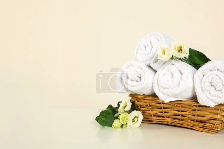 Téléchargez les photos : Serviettes pliées douces et fleurs sur table blanche, espace pour le texte - en image libre de droit