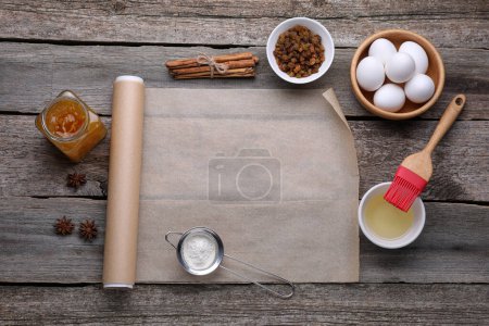 Téléchargez les photos : Rouleau de papier sulfurisé de cuisson, différents ingrédients et outils de cuisine sur table en bois, pose plate. Espace pour le texte - en image libre de droit