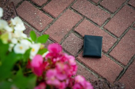 Foto de Billetera negra en pavimento al aire libre, sobre vista. Perdido y encontrado - Imagen libre de derechos