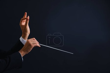 Foto de Conductor profesional con bastón sobre fondo negro, primer plano. Espacio para texto - Imagen libre de derechos