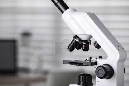 Téléchargez les photos : Microscope médical moderne sur fond flou, gros plan avec espace pour le texte. Equipements de laboratoire - en image libre de droit