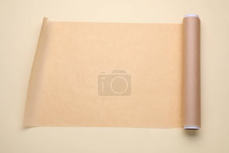 Téléchargez les photos : Rouleau de papier cuisson sur fond beige, vue de dessus - en image libre de droit