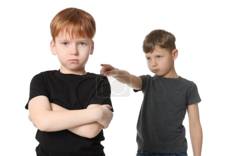 Foto de Un chico apuntando a un chico molesto sobre un fondo blanco. Acoso infantil - Imagen libre de derechos