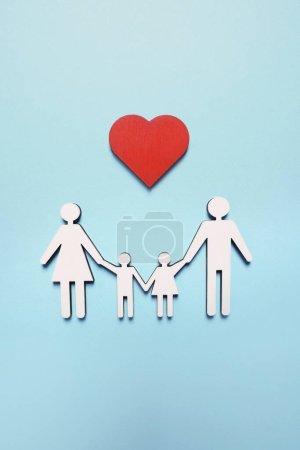 Familien- und Herzfiguren auf hellblauem Hintergrund, Draufsicht. Versicherungskonzept
