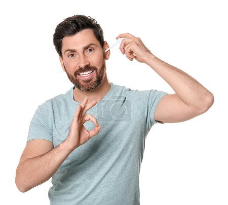 Photo for Man using ear spray and showing ok gesture on white background - Royalty Free Image