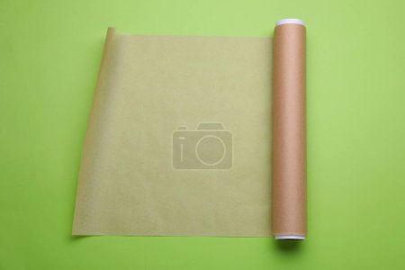 Téléchargez les photos : Rouleau de papier cuisson sur fond vert clair, vue de dessus - en image libre de droit