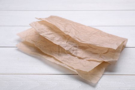 Téléchargez les photos : Feuilles de papier cuisson sur table en bois blanc - en image libre de droit