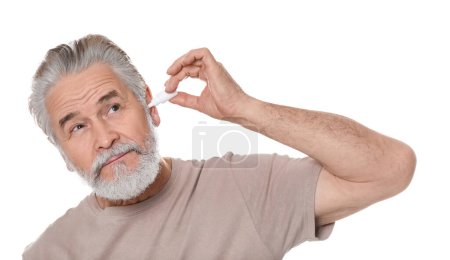 Photo for Senior man using ear drops on white background - Royalty Free Image