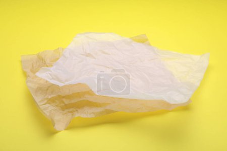 Téléchargez les photos : Feuilles de papier sulfurisé froissé sur fond jaune - en image libre de droit