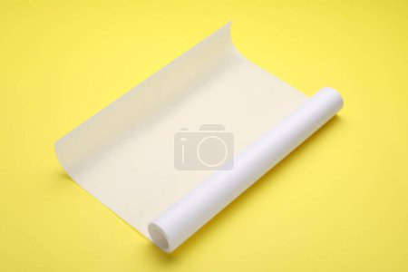 Téléchargez les photos : Rouleau de papier cuisson sur fond jaune - en image libre de droit
