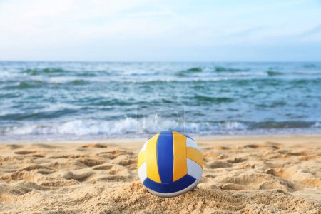 Téléchargez les photos : Ballon de volley coloré sur sable près de la mer - en image libre de droit