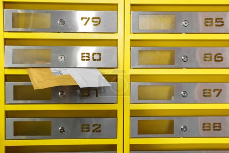 Photo for Metal mailboxes with keyholes, numbers and correspondence in post office - Royalty Free Image