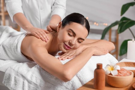 Téléchargez les photos : Belle femme recevant un massage du dos dans un salon de beauté, gros plan - en image libre de droit