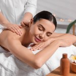 Beautiful woman receiving back massage in beauty salon, closeup