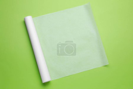 Téléchargez les photos : Rouleau de papier cuisson sur fond vert clair, vue de dessus - en image libre de droit