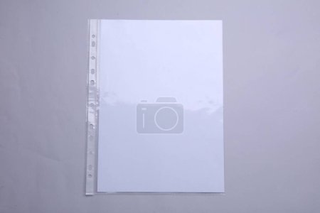 Foto de Bolsillo perforado con hoja de papel sobre fondo gris claro, vista superior - Imagen libre de derechos