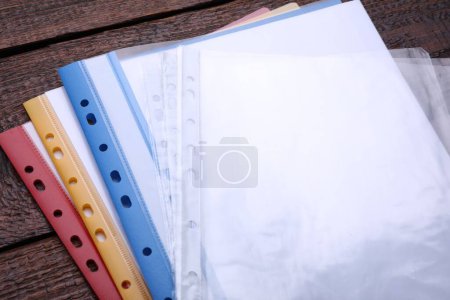 Foto de Carpetas de archivo con bolsillos perforados en mesa de madera - Imagen libre de derechos