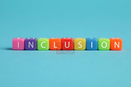 Foto de Cubos de colores con palabra Inclusión sobre fondo azul claro - Imagen libre de derechos