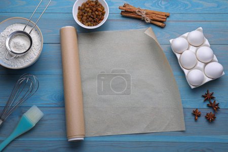 Téléchargez les photos : Papier sulfurisé, outils de cuisine et différents ingrédients sur une table en bois bleu clair, pose plate. Espace pour le texte - en image libre de droit