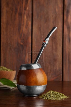 Photo for Calabash with mate tea and bombilla on wooden table - Royalty Free Image