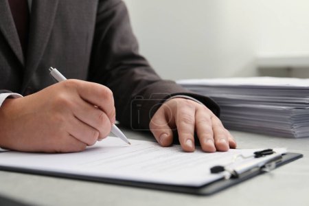 Photo for Man signing document at table in office, closeup - Royalty Free Image