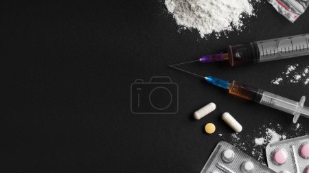 Different hard drugs on black background, flat lay. Space for text