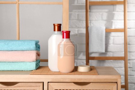 Téléchargez les photos : Shampooing solide bar et bouteilles de produits cosmétiques sur table en bois dans la salle de bain - en image libre de droit
