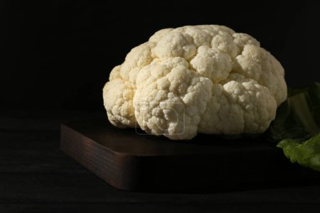 Photo for Fresh raw cauliflower on black wooden table, closeup - Royalty Free Image