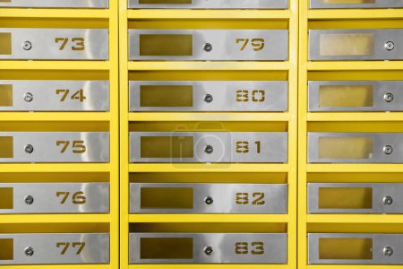 Many closed metal mailboxes with keyholes and numbers as background