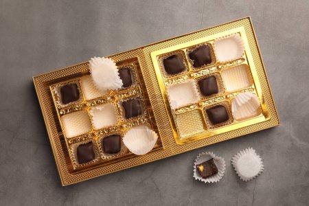 Foto de Caja parcialmente vacía de caramelos de chocolate sobre fondo gris, vista superior - Imagen libre de derechos