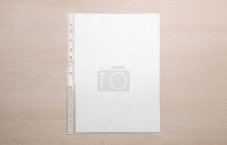 Foto de Bolsillo perforado con hoja de papel sobre mesa de madera, vista superior - Imagen libre de derechos