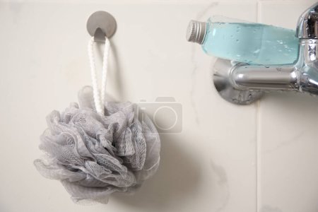 Téléchargez les photos : Bouffée de douche grise et bouteille de gel de lavage du corps dans la salle de bain - en image libre de droit