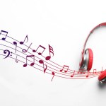 Staff with music notes flowing from red headphones on white background, top view