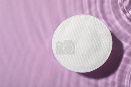 Foto de Almohadilla de algodón y agua micelar sobre fondo violeta, vista superior. Espacio para texto - Imagen libre de derechos