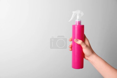 Photo for Woman holding spray bottle with hair thermal protection on white background, closeup. Space for text - Royalty Free Image
