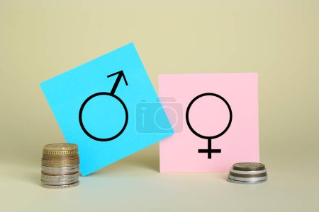 Foto de Diferencia salarial de género. Símbolos masculinos y femeninos cerca de pilas de monedas sobre fondo beige - Imagen libre de derechos