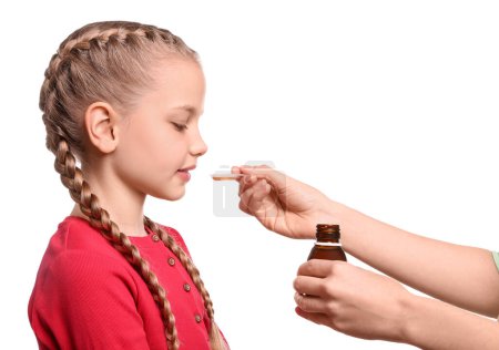 Téléchargez les photos : Mother giving syrup to her daughter from dosing spoon against white background - en image libre de droit