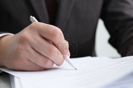 Photo for Man signing document at table in office, closeup - Royalty Free Image