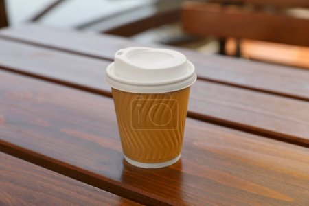 Photo for Takeaway paper cup with coffee on wooden table, closeup - Royalty Free Image