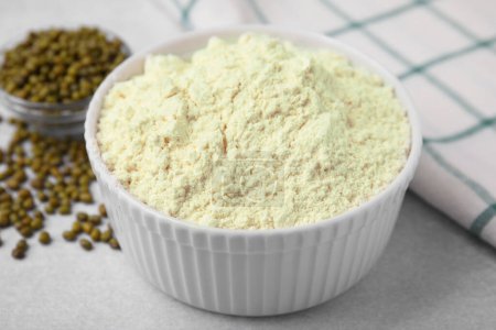 Téléchargez les photos : Mung bean flour in bowl and seeds on white table, closeup - en image libre de droit