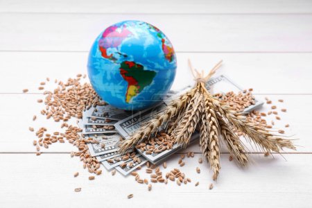 Globe, ears of wheat and banknotes on white wooden table. Import and export concept