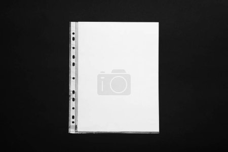 Foto de Punched pocket with paper sheet on black background, top view - Imagen libre de derechos
