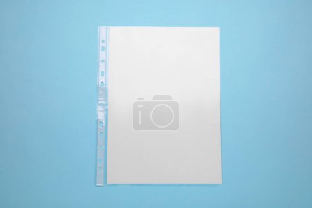 Foto de Punched pocket with paper sheet on turquoise background, top view - Imagen libre de derechos
